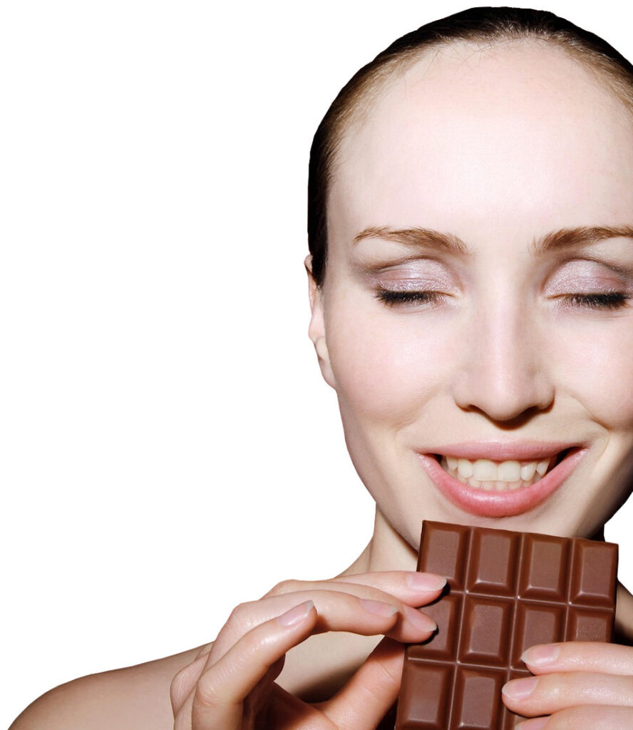 Mulher com uma tablet de chocolate, mostrando satisfação pelo aroma